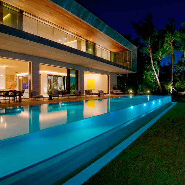 piscine transparente à débordement la nuit par Oppenheim Architecture