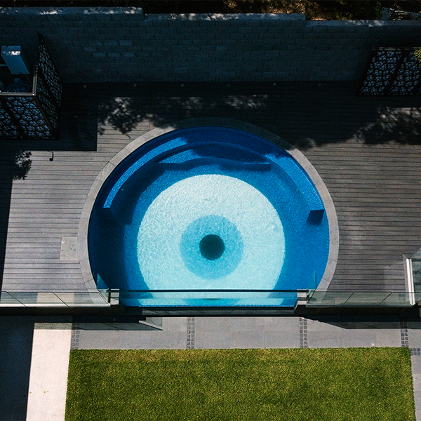 vue drone d´une piscine ronde avec paroi vitrée transparente