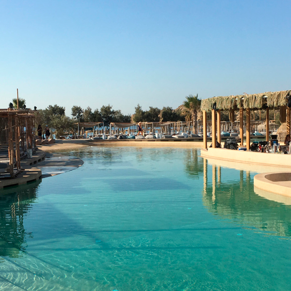 piscina tipo playa en resort con hamas y espacios chill out alrededor