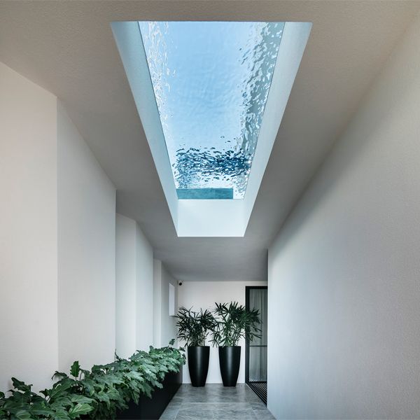 piscine privée avec sol transparent vue depuis le couloir de la maison, par Aloha Pools